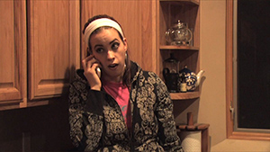 A woman talking on a cell phone in a kitchen.