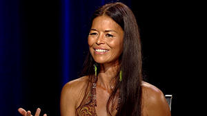 A woman with long hair sitting in a chair.