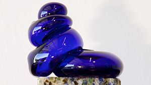 A blue glass sculpture on top of a rock.