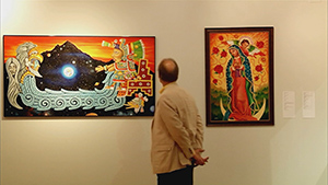 A man looking at paintings in an art gallery.