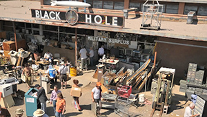 A group of people standing in front of a black hole.