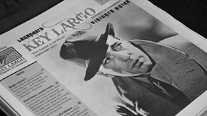 A newspaper with a picture of a man in a hat.