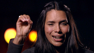 A woman with long hair is waving her hand in the air.