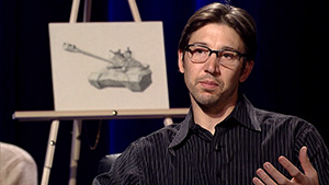 A man sitting in front of a drawing of a tank.