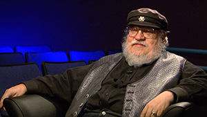 A man with a beard sitting in a chair.