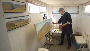 A man painting in a studio.