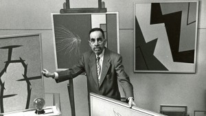 A man in a suit standing in front of a painting.
