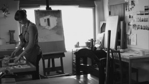 A black and white photo of a woman in a studio.