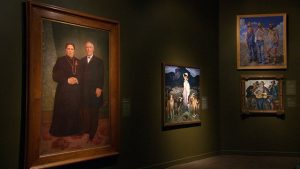 A group of paintings on display in a museum.