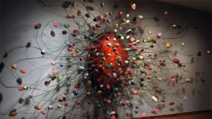 A large sculpture of colorful balls hanging on a wall.