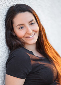 A woman leaning against a wall.