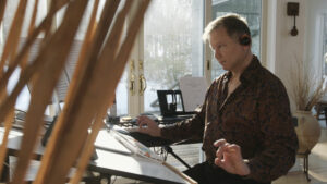 A man sits at a table composing music