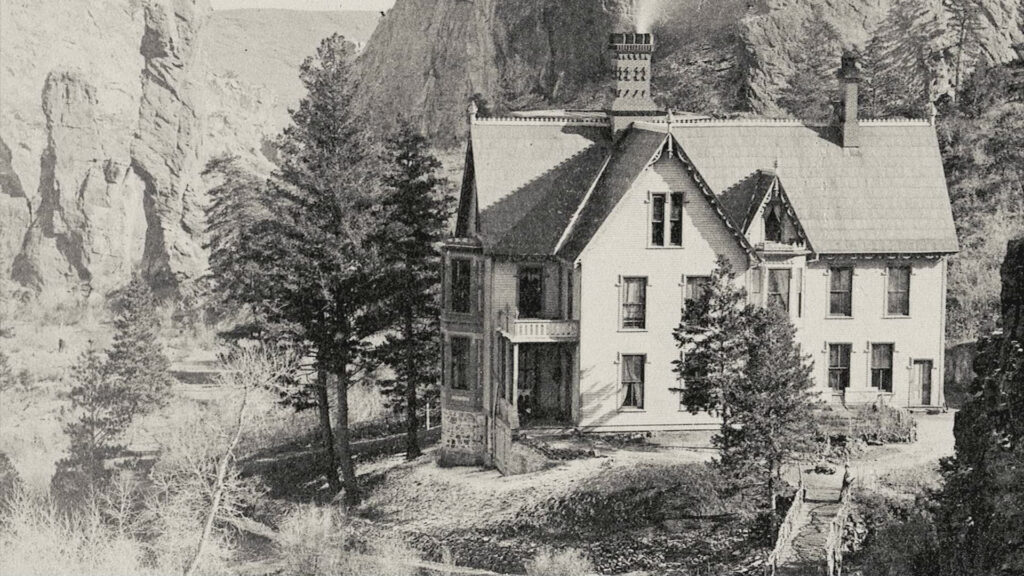 A black and white image of a whole in the mountains with trees