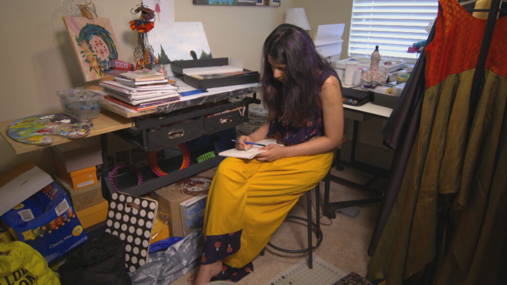 A person sits in an studio sketching