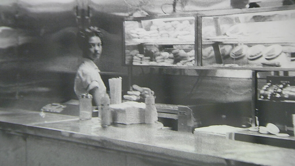 A black and white photograph of a waitress at a diner