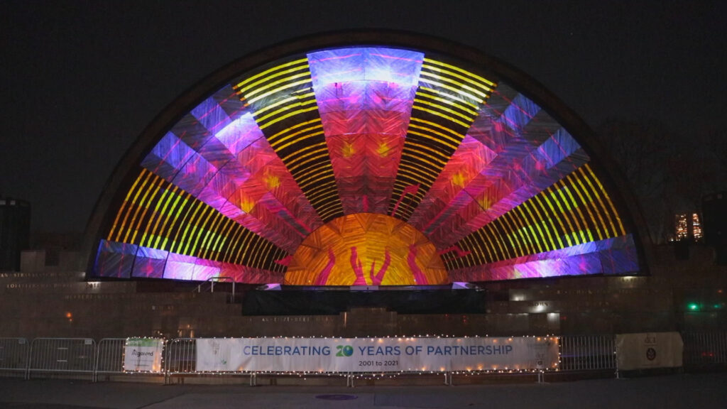 A dome with lights projected on it at night