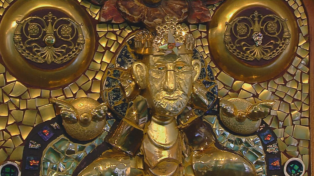 An ornate gold sculpture with a person in the middle