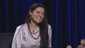 Kathleen Wall smiling during an interview sitting next to her nativity scene.