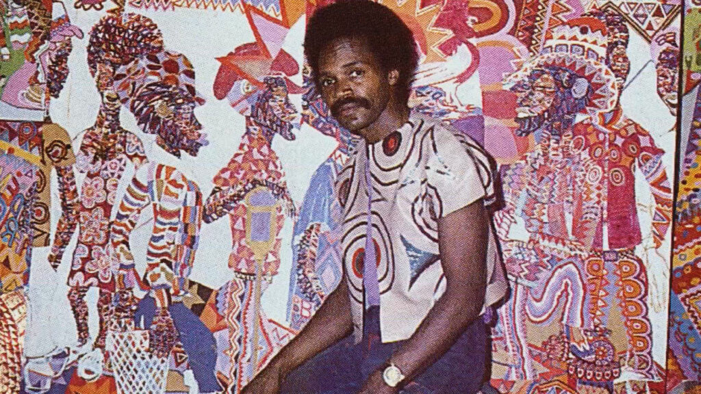 A person standing in front of an example of the visual aesthetic called "Africobra."