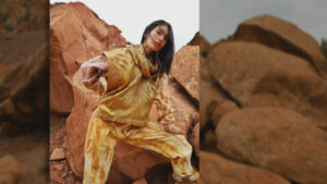 A model posing on rocks wearing a jumpsuit.