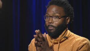 Hakim Bellamy speaking and making hand gestures.