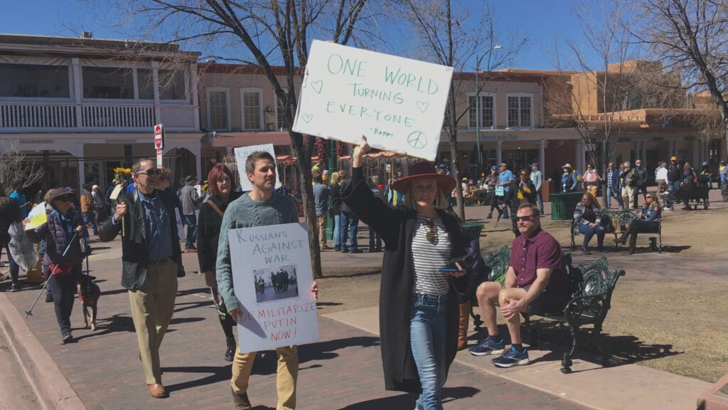 A group of people with protest signs in the Ukraine March in Santa Fe.