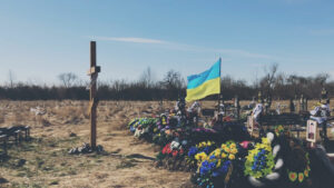 A cemetary with a Ukraine flag flying.