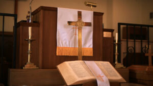 A church podium with the bible and a cross at Reverend Margaret McFadden's church.