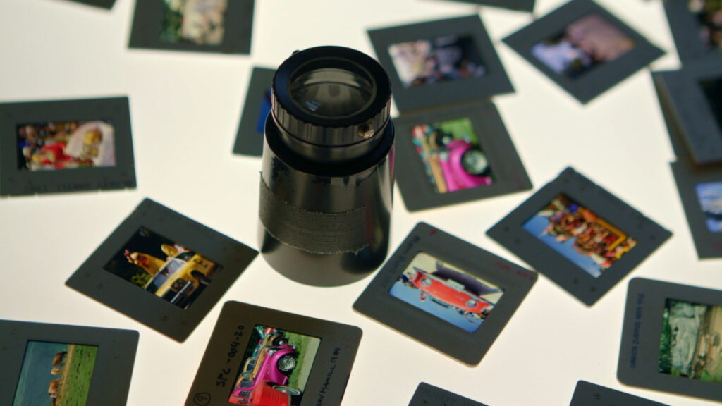 A camera lens with photo cells scattered on a lit surface.