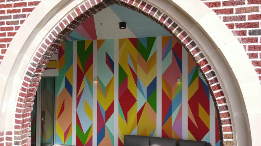 An archway of the Sarasota Art Museum building with a colorful mural inside.