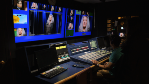 A group of people in a room with a large number of monitors.