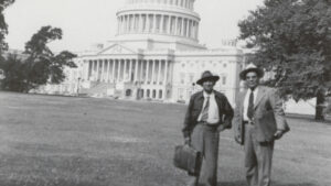 Two men standing in front of the capitol building.