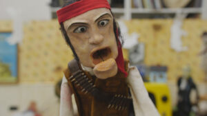 A wooden puppet of a pirate wearing a bandana.
