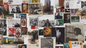 A wall with many pictures and photos on it.