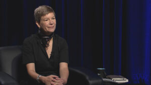 A woman sitting in a chair with a microphone.