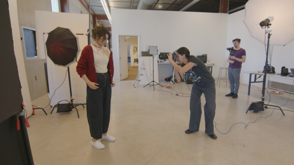 A group of people standing in front of a camera in a studio.