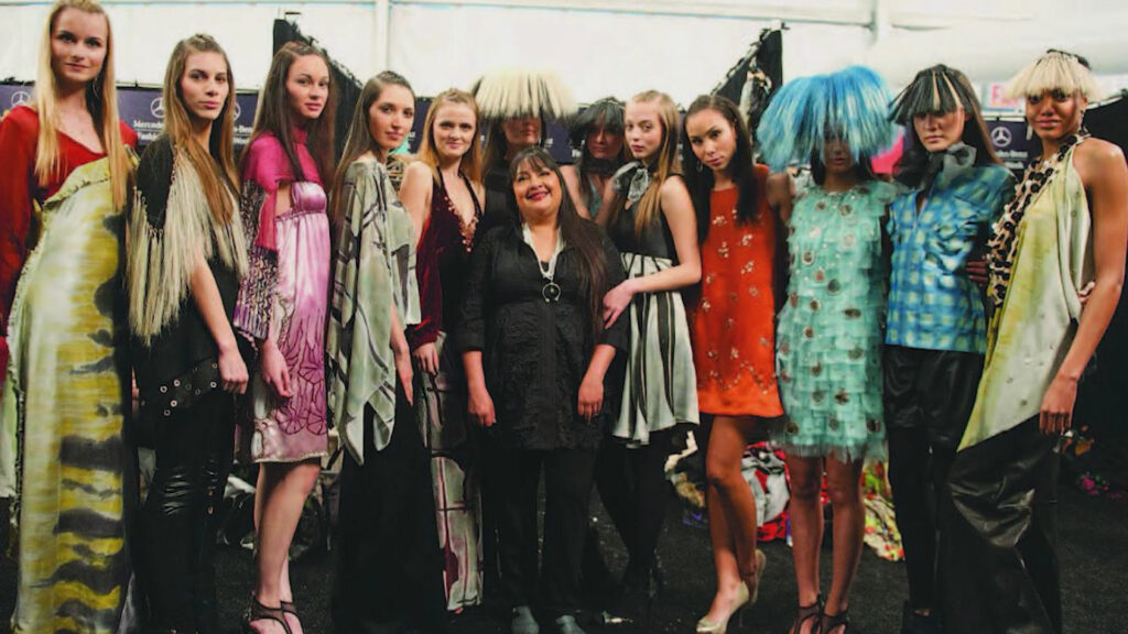 A group of women posing for a photo at a fashion show.