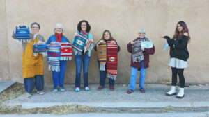 A group of women standing in front of a wall.