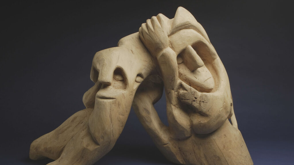 A wooden sculpture of a man and a woman.
