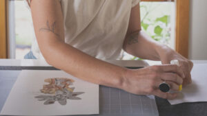 A woman is drawing on a piece of paper.