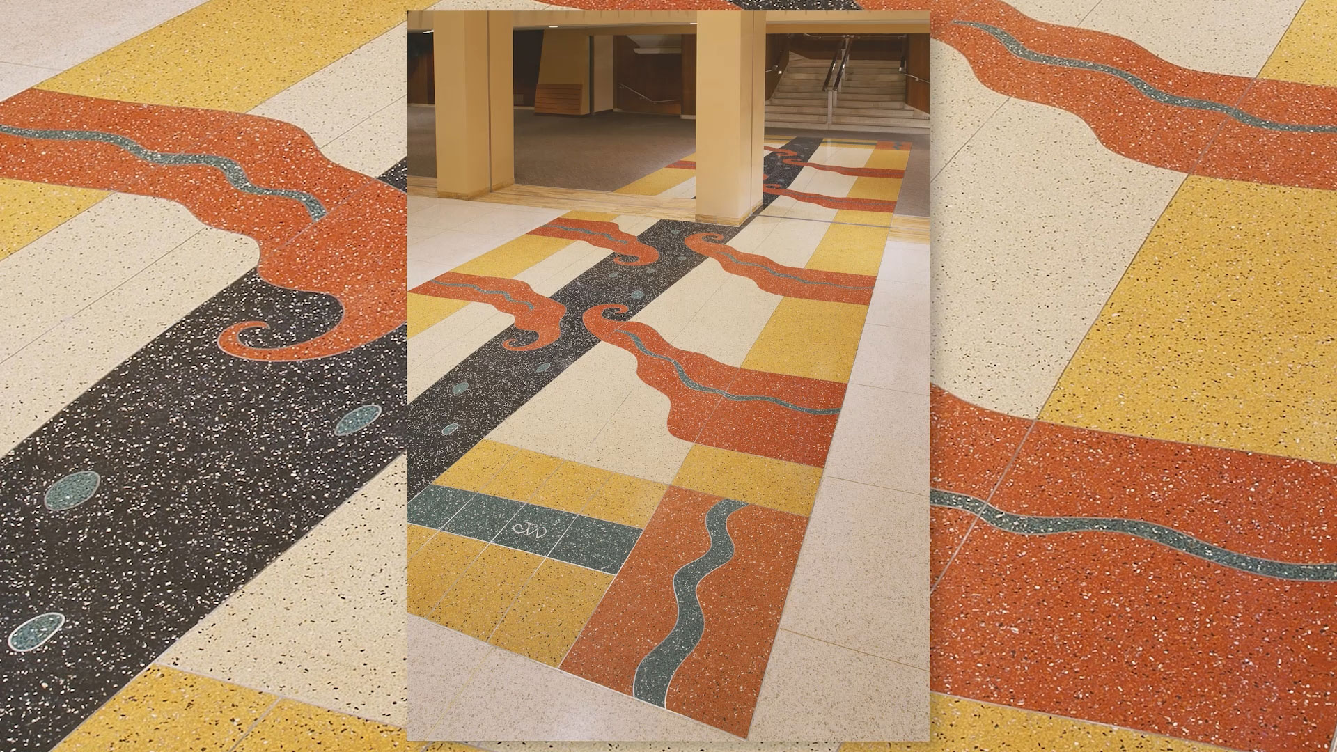 Colorful terrazzo floor with abstract patterns in black, red, yellow, and blue, featuring wavy and geometric shapes in a public indoor space.