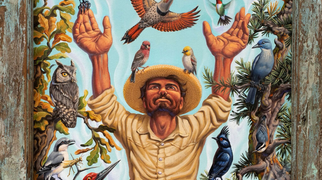 A man in a straw hat stands with raised arms, surrounded by various colorful birds perched on his hands, shoulders, and nearby branches.