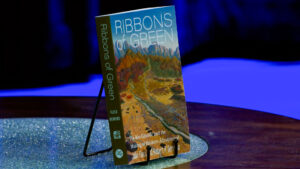 Book titled Ribbons of Green: The Rio Grande and the Making of Modern Albuquerque by John Fleck and Robert P. Berrens, displayed on a stand.