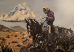 A person wearing a helmet and shorts rides a horse through a dry, grassy landscape with mountains and clouds in the background.