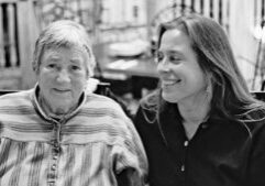 A woman and a woman smiling.