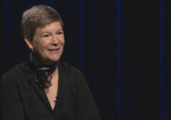A woman in a black shirt sitting in a chair.