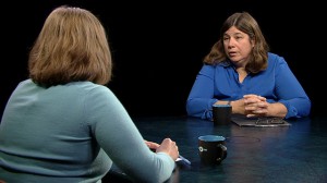 Two women sitting at a table talking.