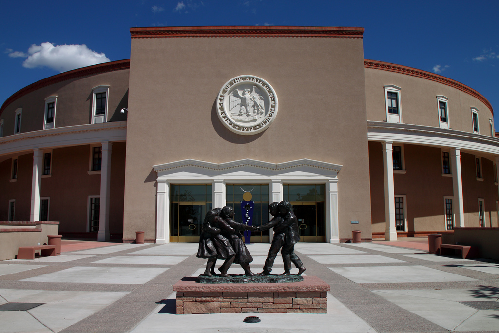 A statue of a group of people in front of a building.