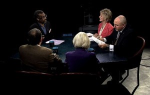 A group of people sitting around a table in a dark room.