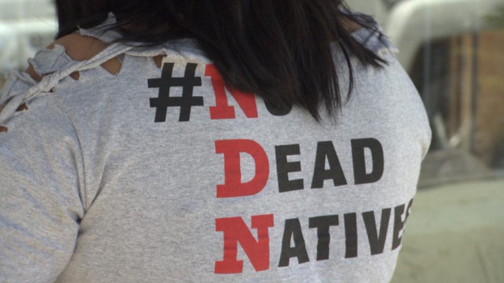 A woman wearing a shirt that says no dead native.